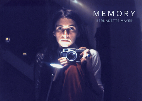 Young Bernadette Mayer holding a camera below her face, pointed towards viewer